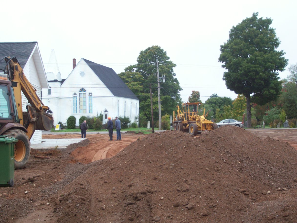 Adding new gravel to build up the parking lot.